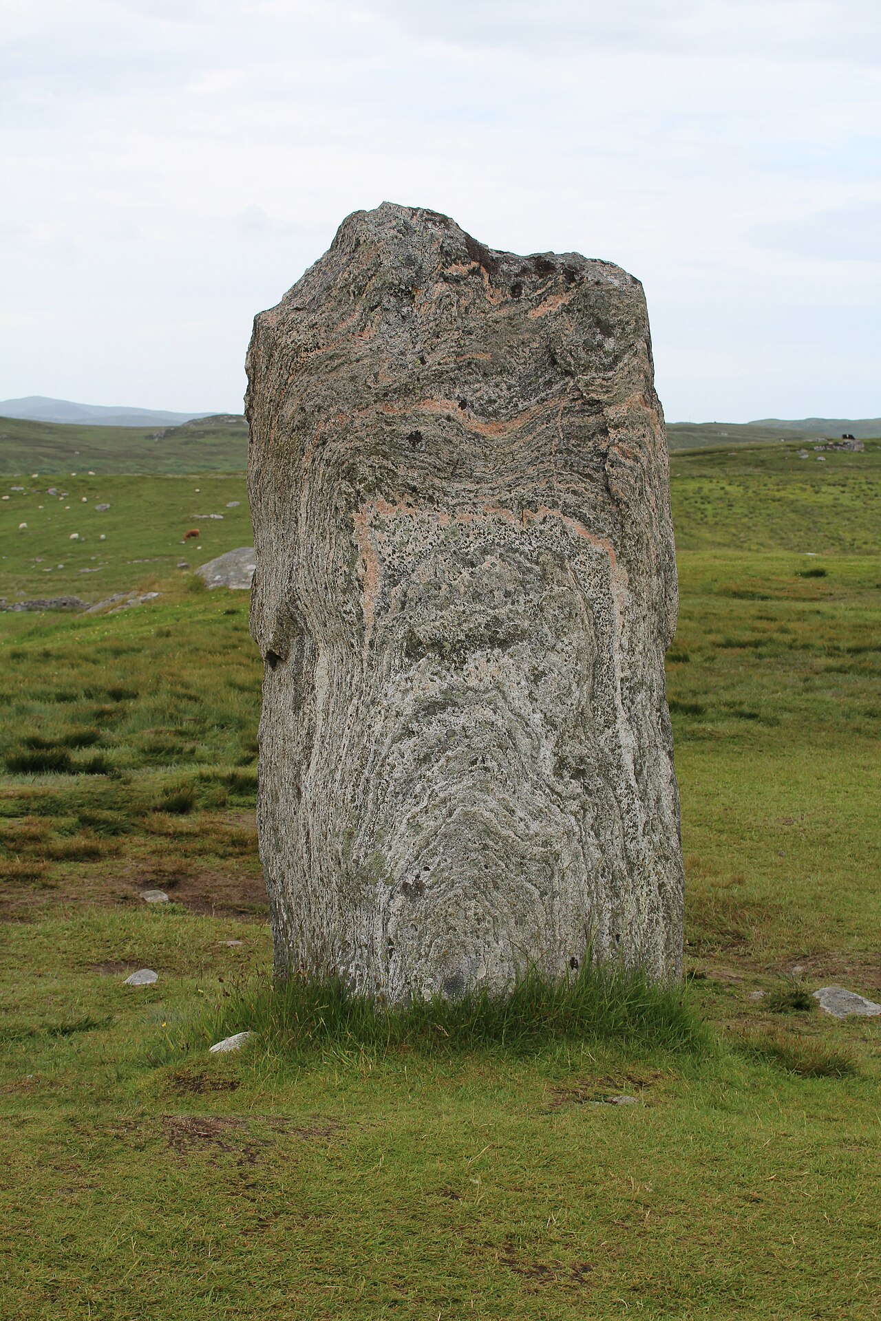 The Callanish standing stones on the Isle of Lewis, tall weathered gneiss monoliths against a bright sky
